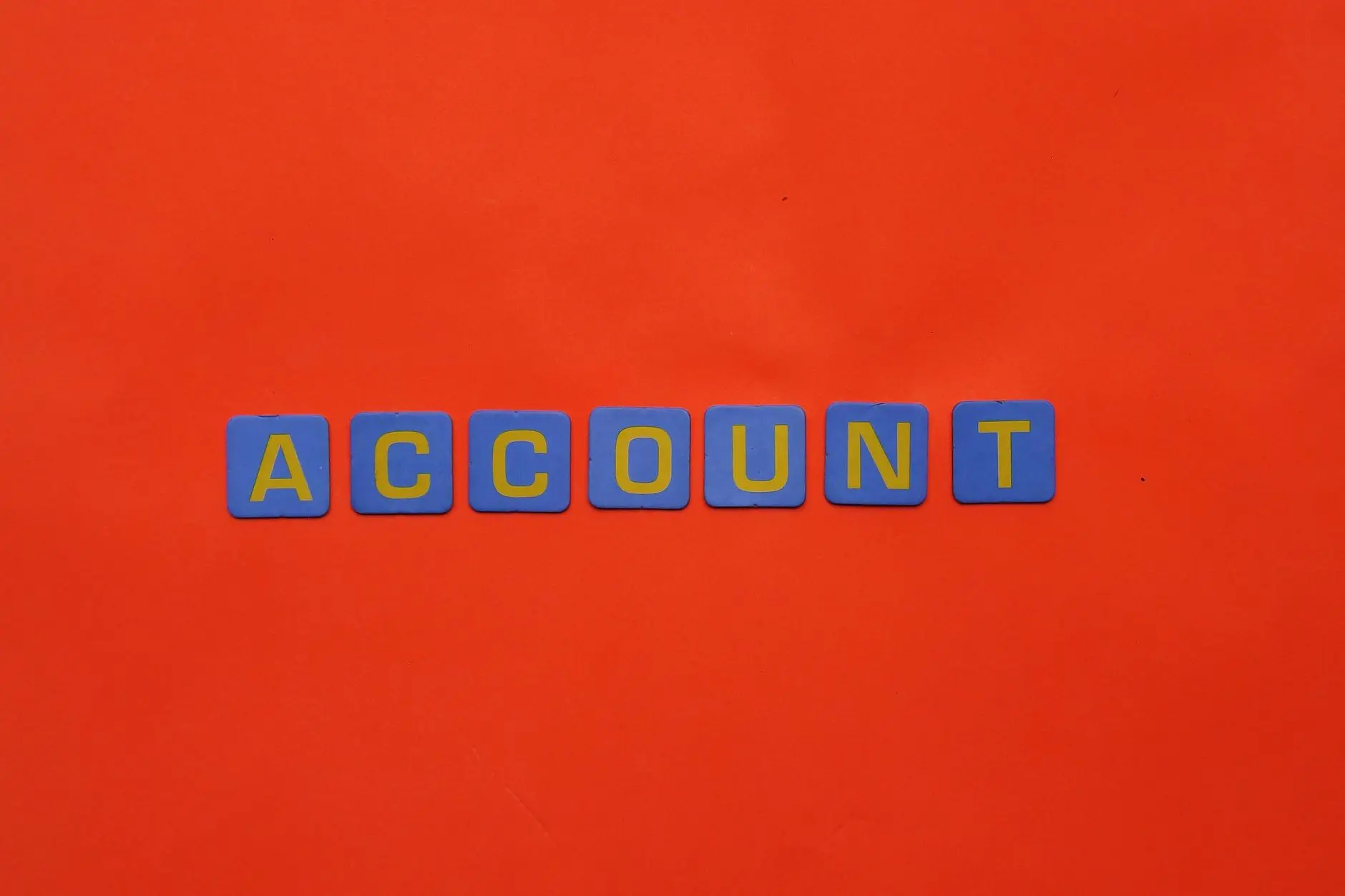 Close-up of a red surface with the word ACCOUNT in bold, scattered letters viewed from different angles.